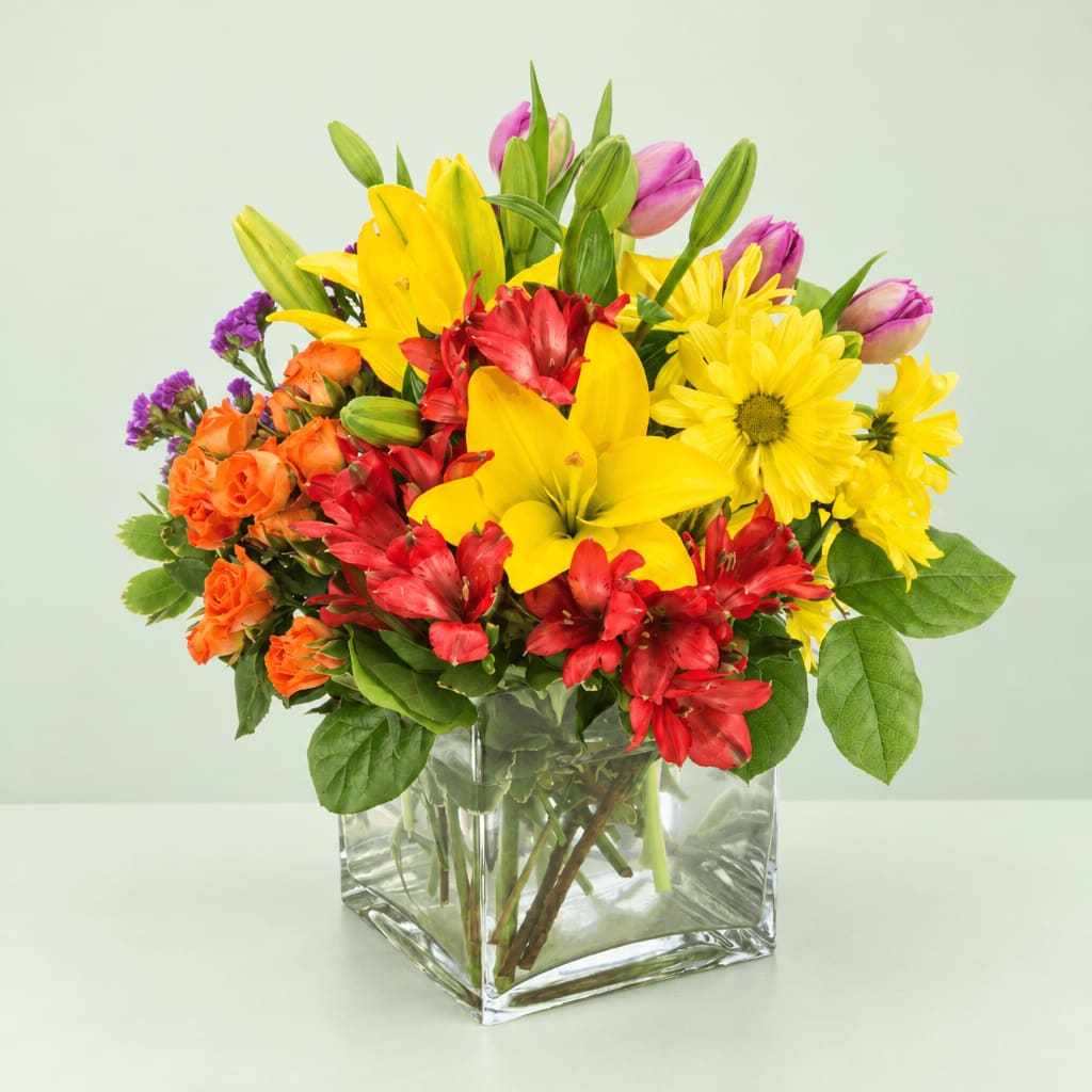 Colorful mixed bouquet in a clear square glass vase