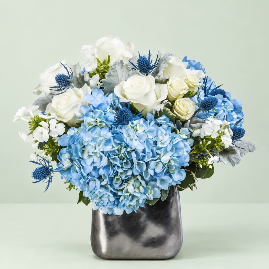 Blue and white flower arrangement in a metallic vase