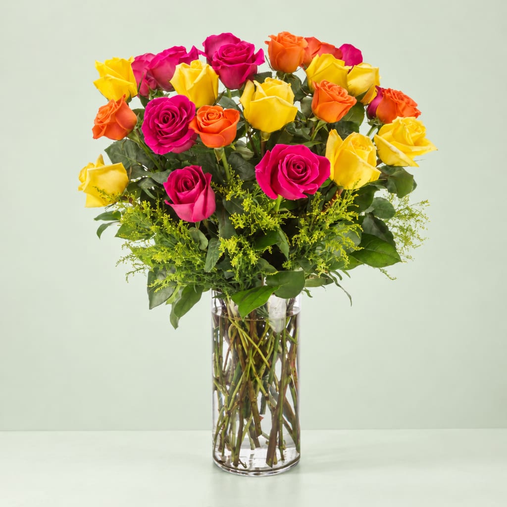 Bouquet of yellow, pink, and orange roses in a clear glass vase