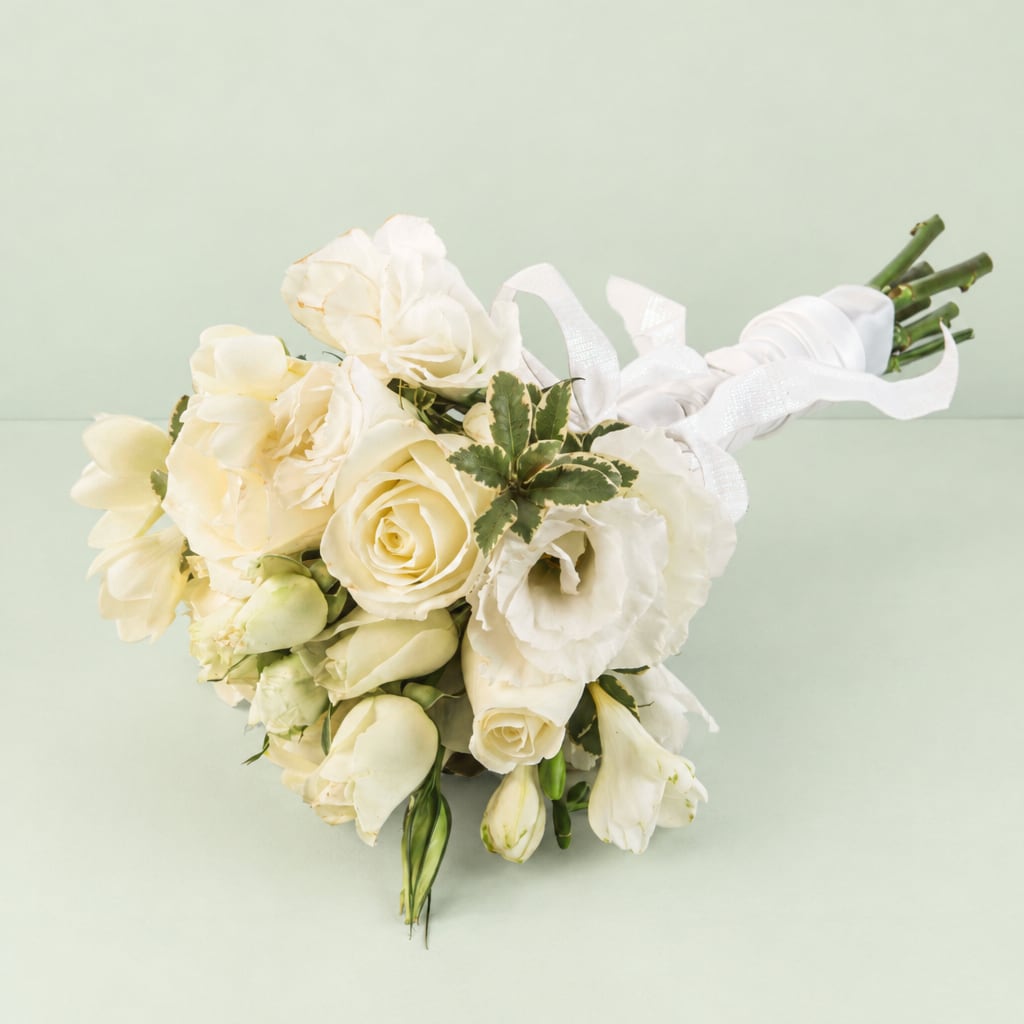 Creamy white bouquet with roses and tulips tied with a white ribbon