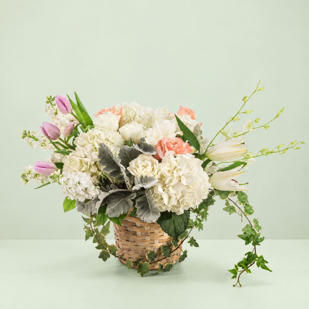 Basket arrangement of white and pink flowers with trailing ivy