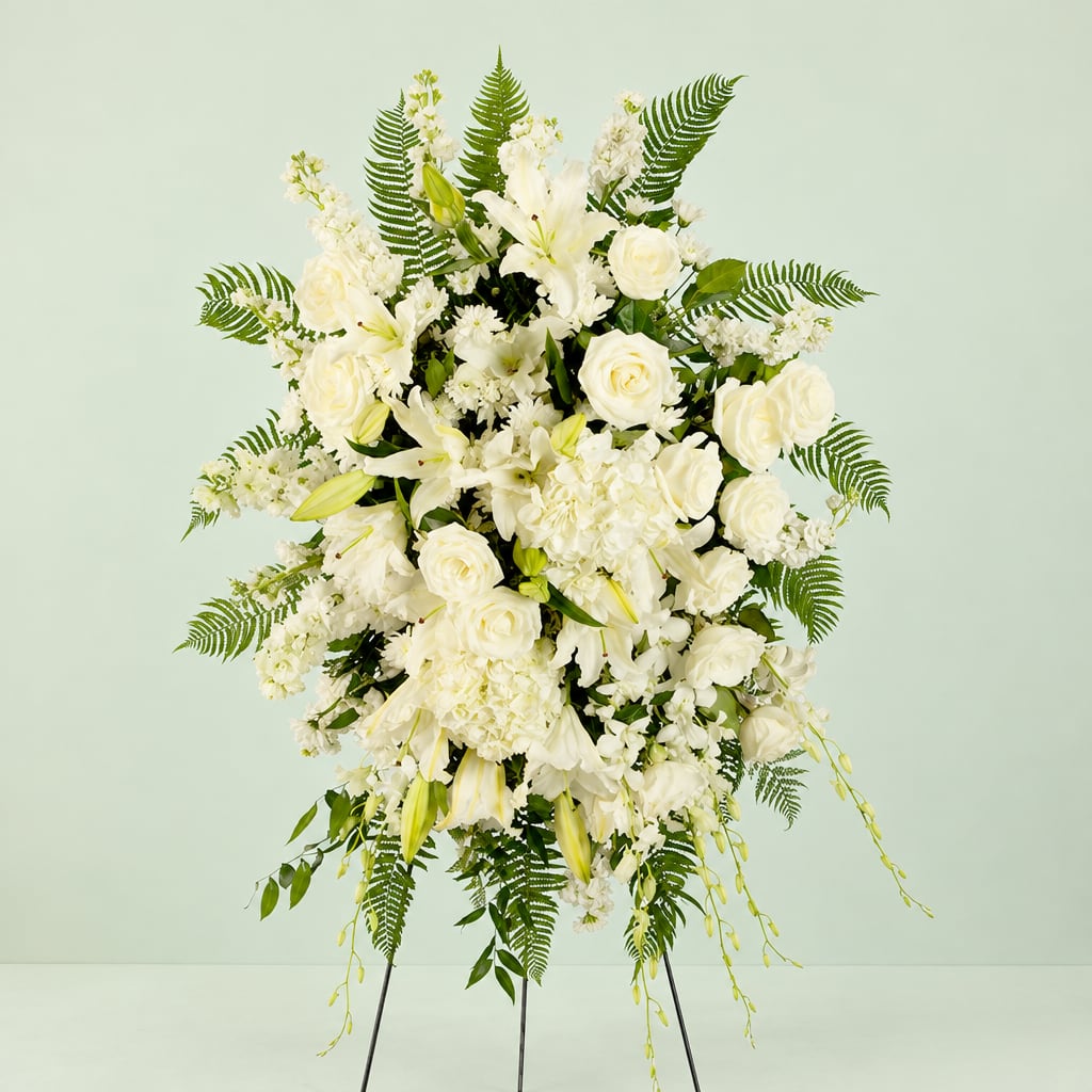 White floral standing spray with roses, lilies, and ferns