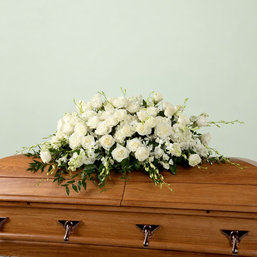 White rose arrangement on a wooden casket
