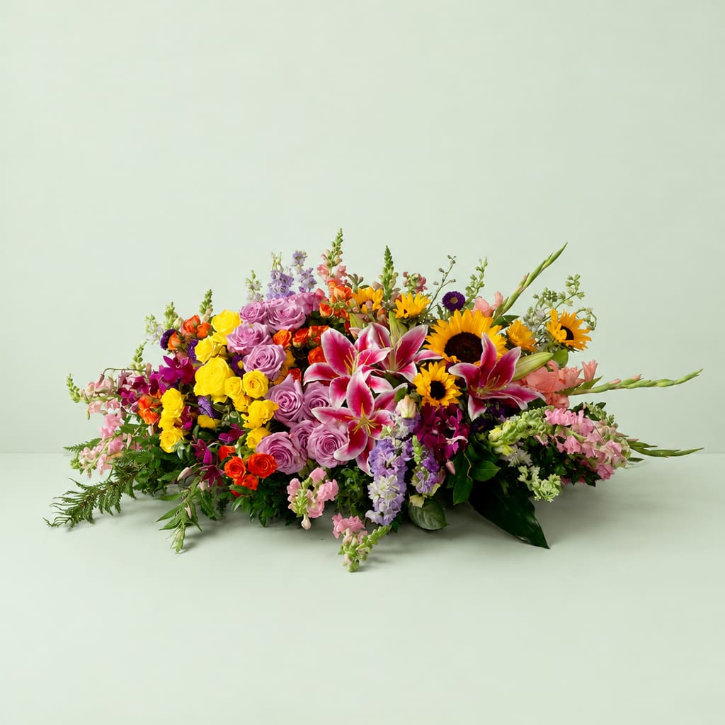 Colorful mixed flower arrangement with lilies, roses, and sunflowers