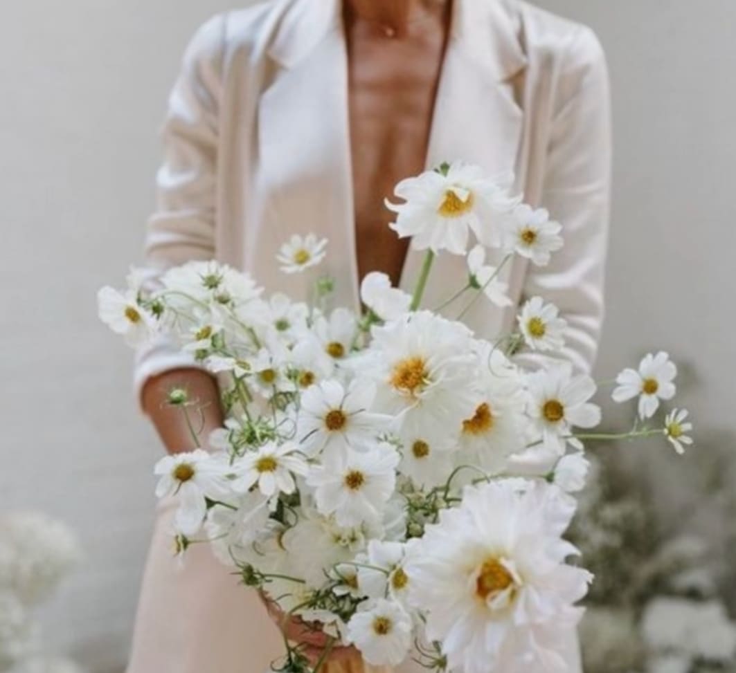 Woman holding a loose bouquet of white daisy-like flowers