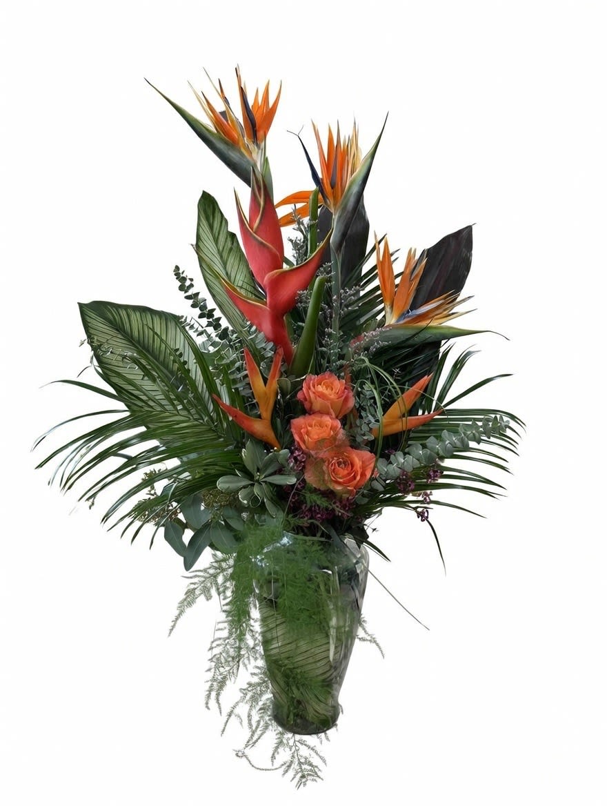 Tropical bouquet with orange bird of paradise and roses in a glass vase