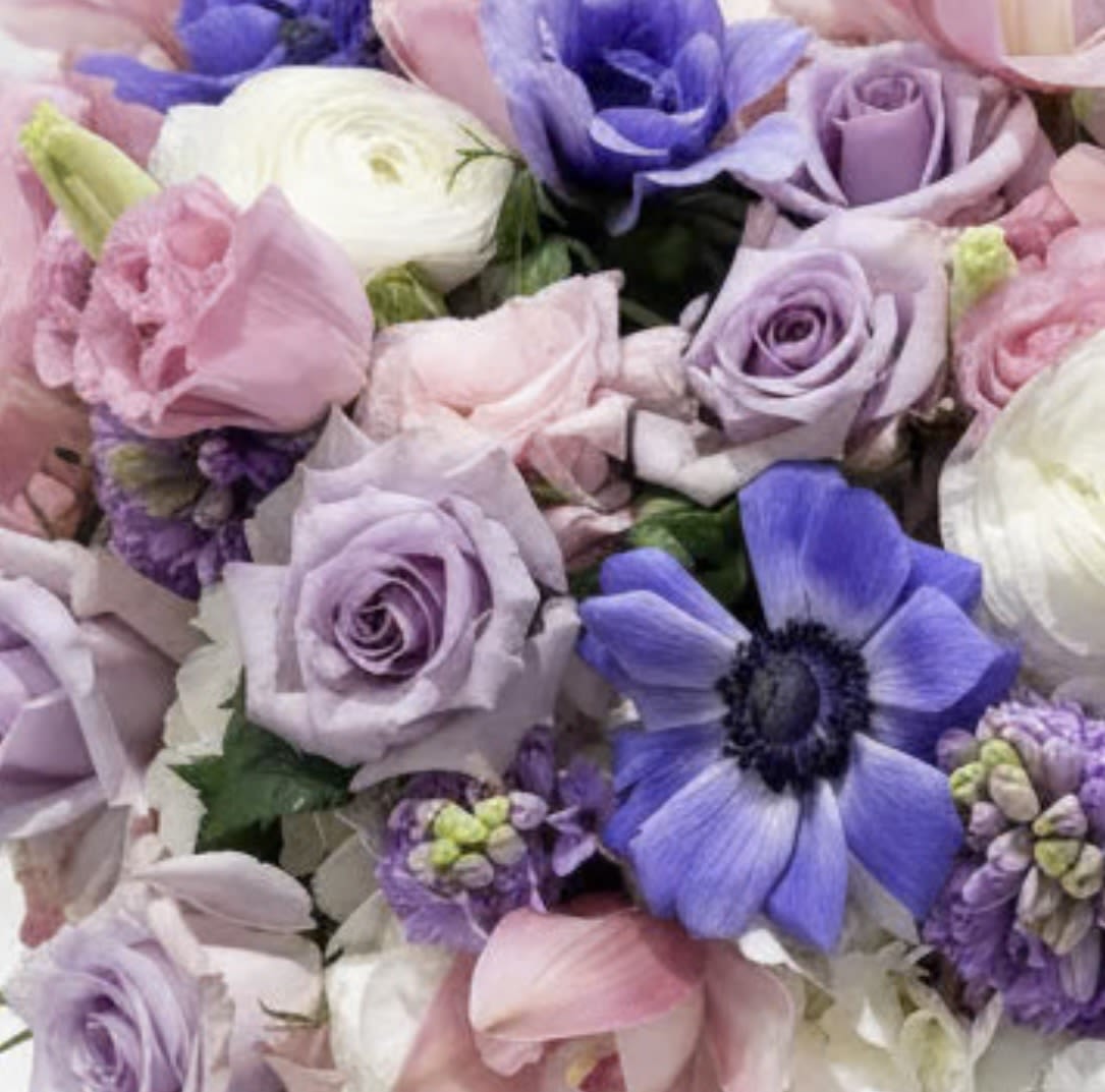 Bouquet of pastel roses, ranunculus, and purple anemones