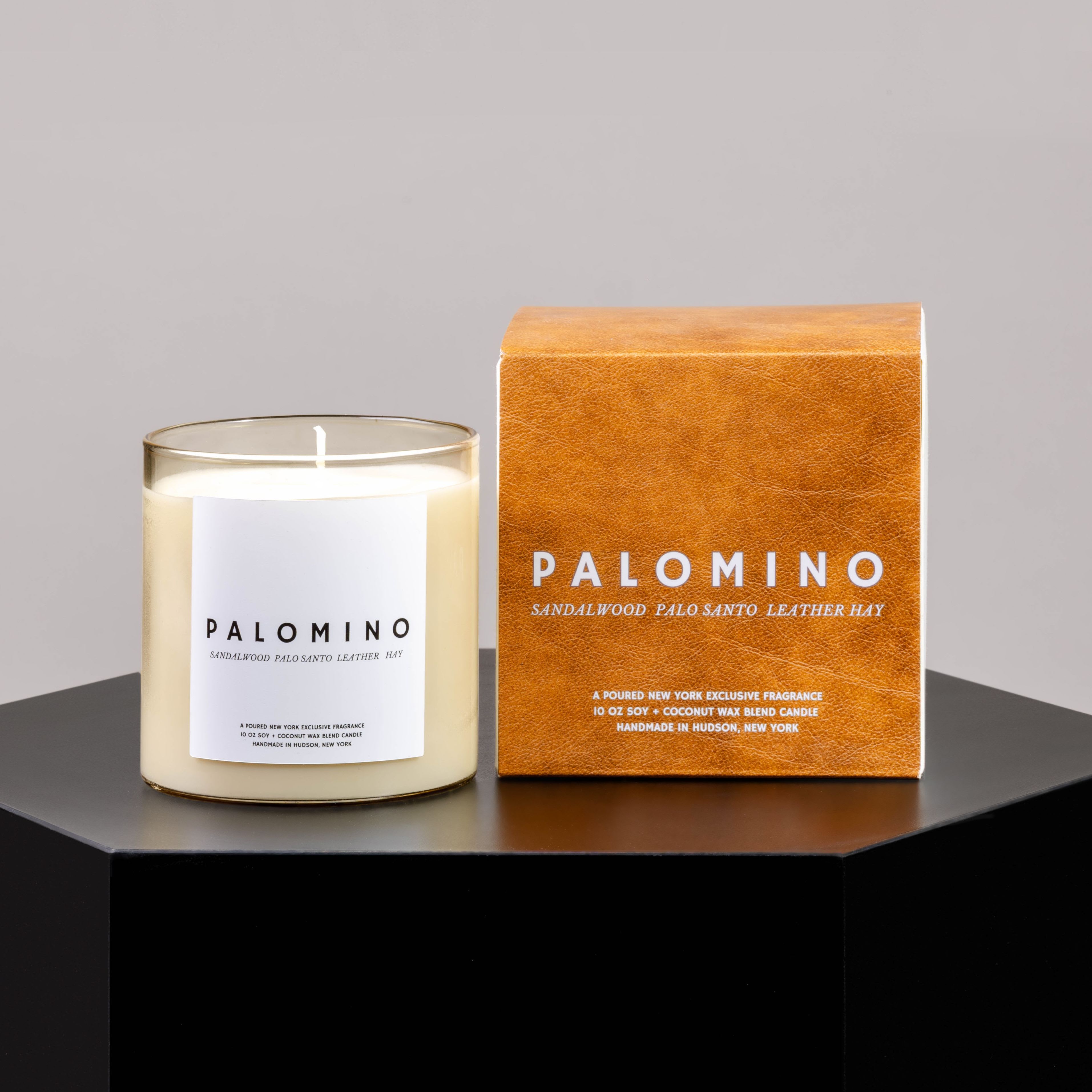 Scented candle in a glass jar beside its orange box