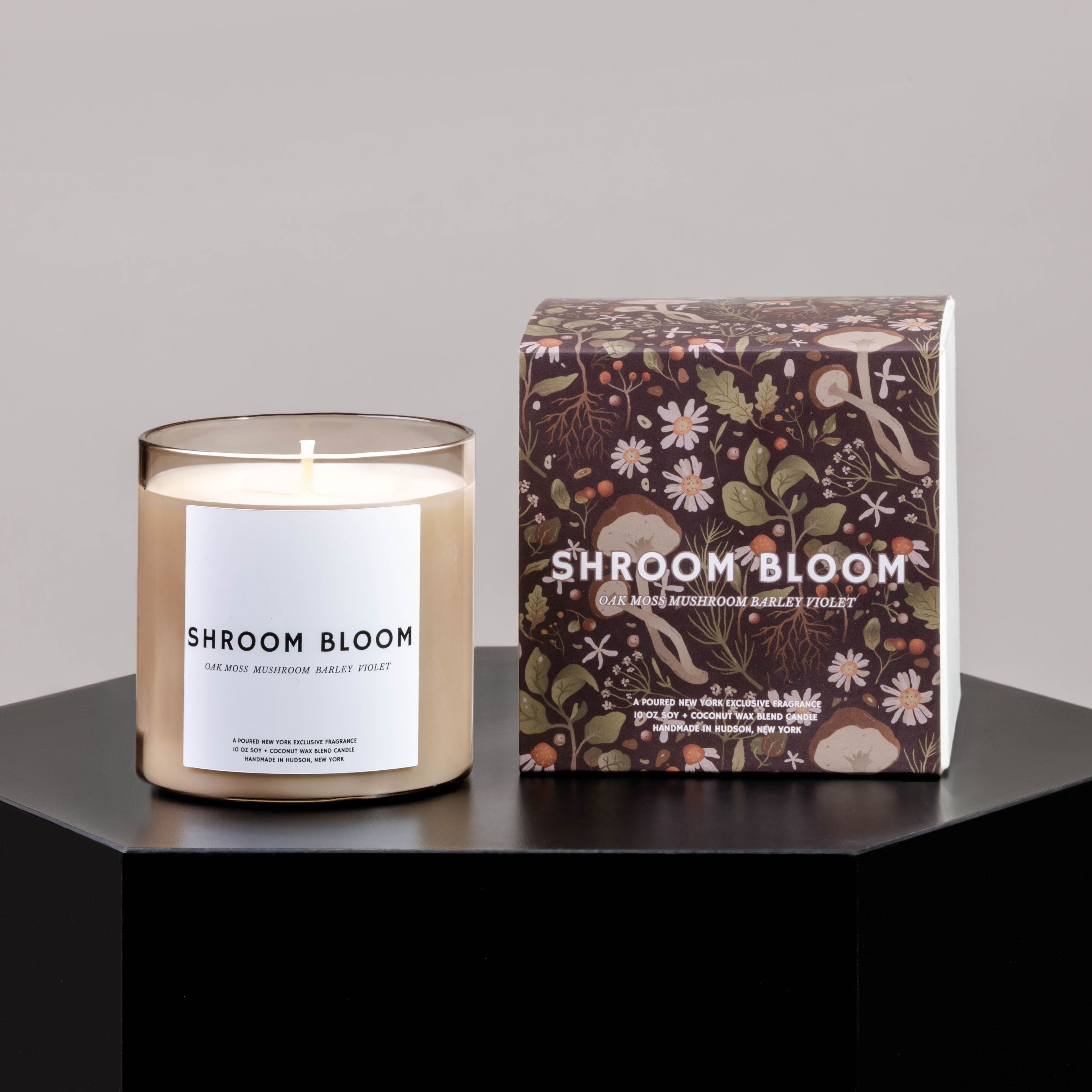 Scented candle in a glass jar beside its floral-patterned box
