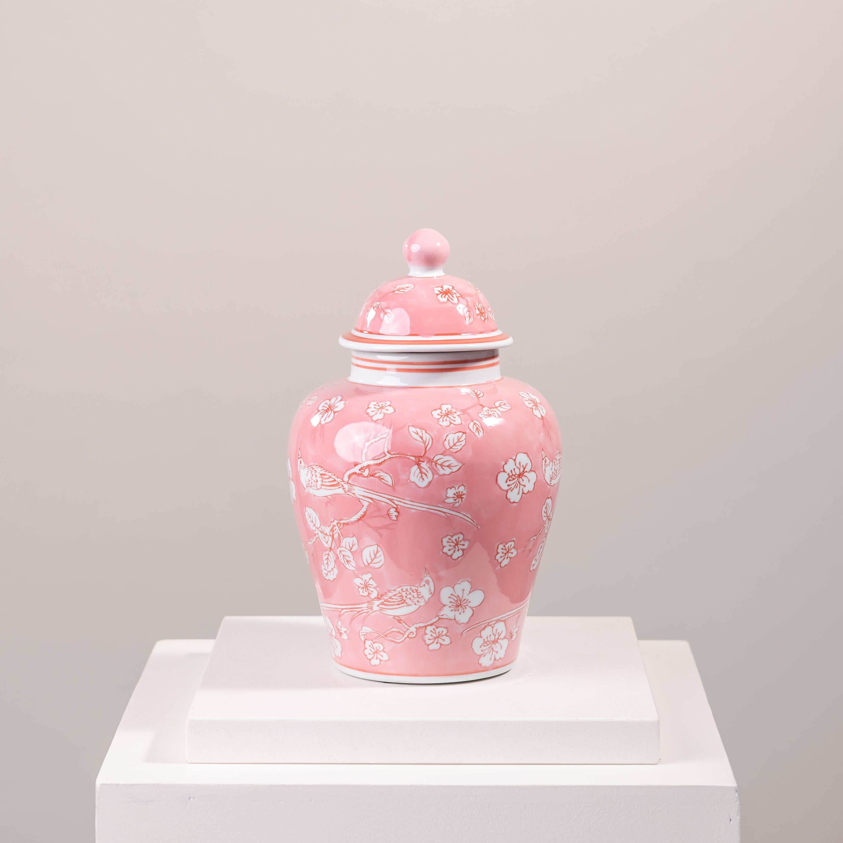 Pink ceramic lidded jar with white floral and bird pattern