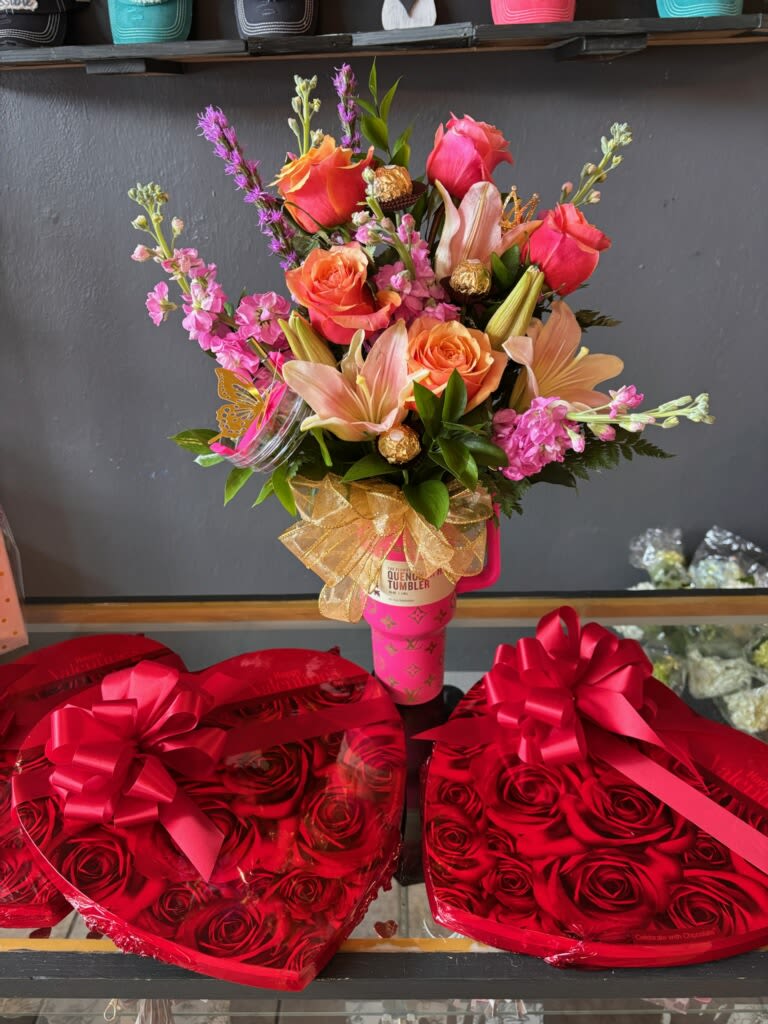 Pink and orange bouquet in a pink tumbler, with heart-shaped rose boxes below.