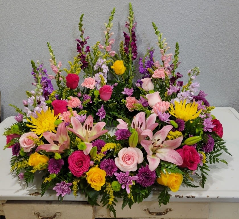 Large colorful floral arrangement with roses, lilies, and snapdragons