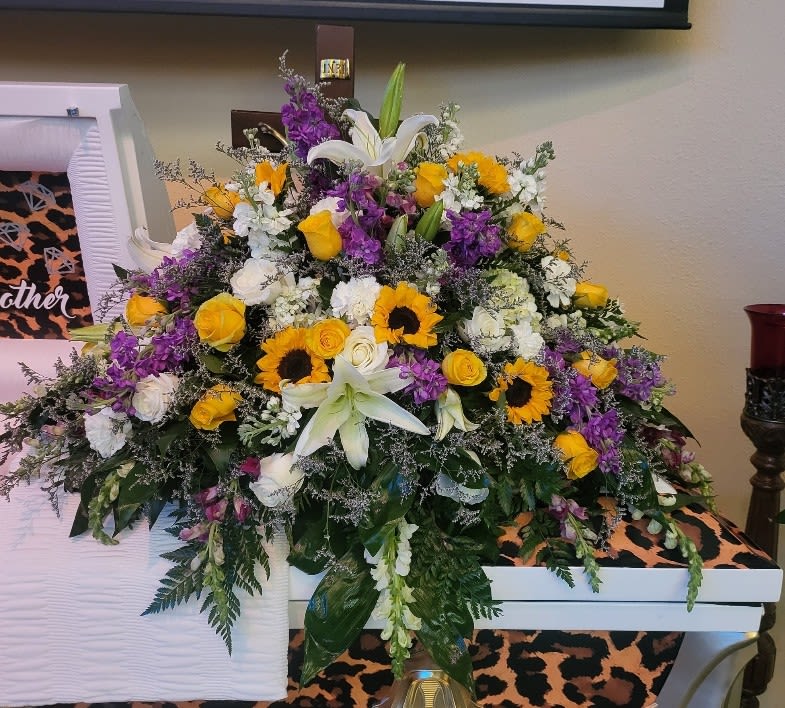 Large mixed floral arrangement with lilies, roses, and sunflowers