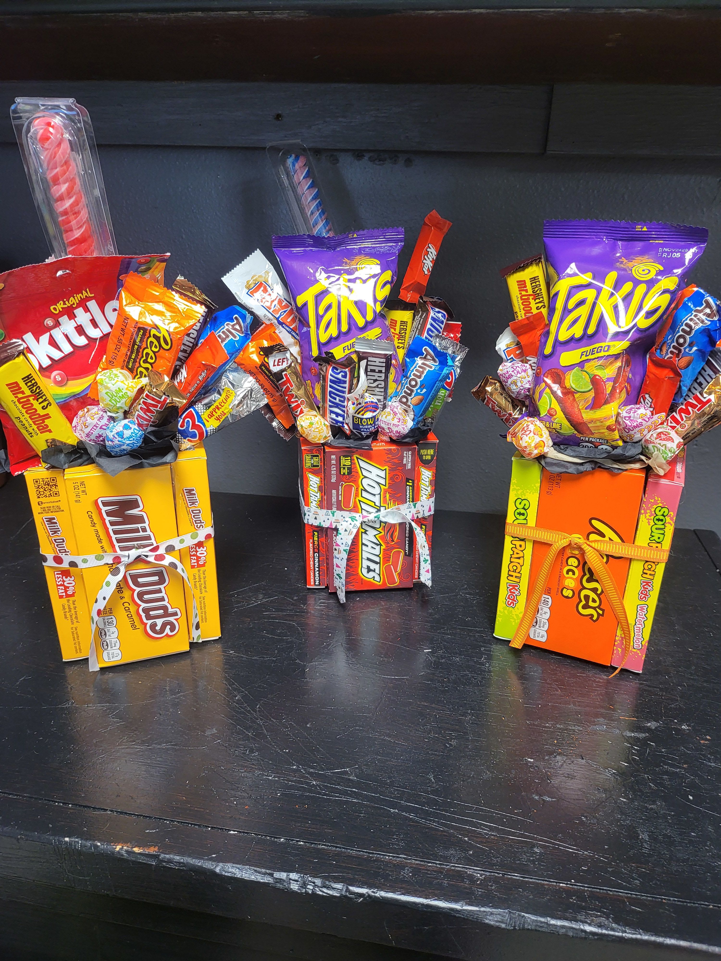 Three candy gift boxes filled with assorted sweets and tied with ribbons