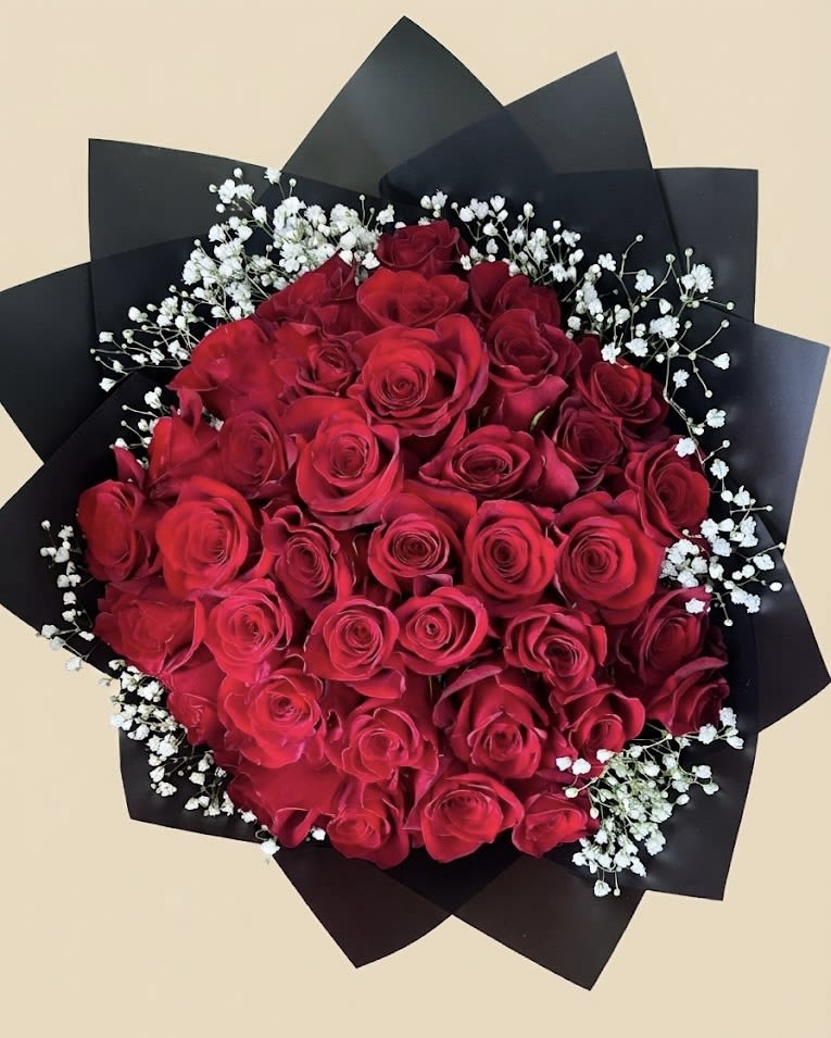 Bouquet of red roses with white baby's breath in black wrap