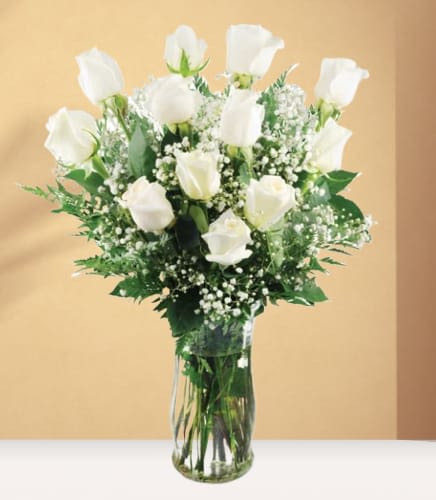 White roses in a clear glass vase with baby's breath