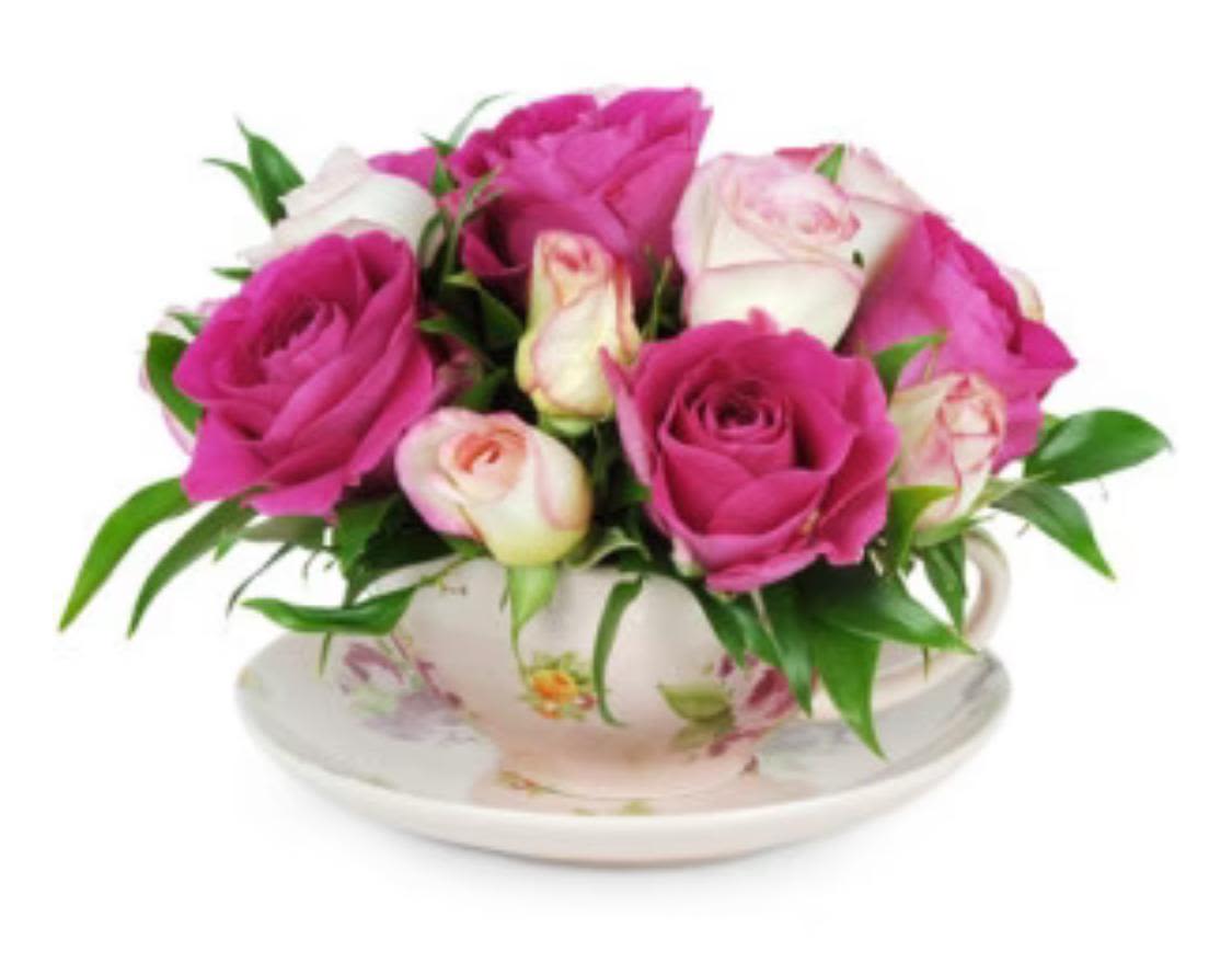Pink and white roses arranged in a floral teacup on a saucer