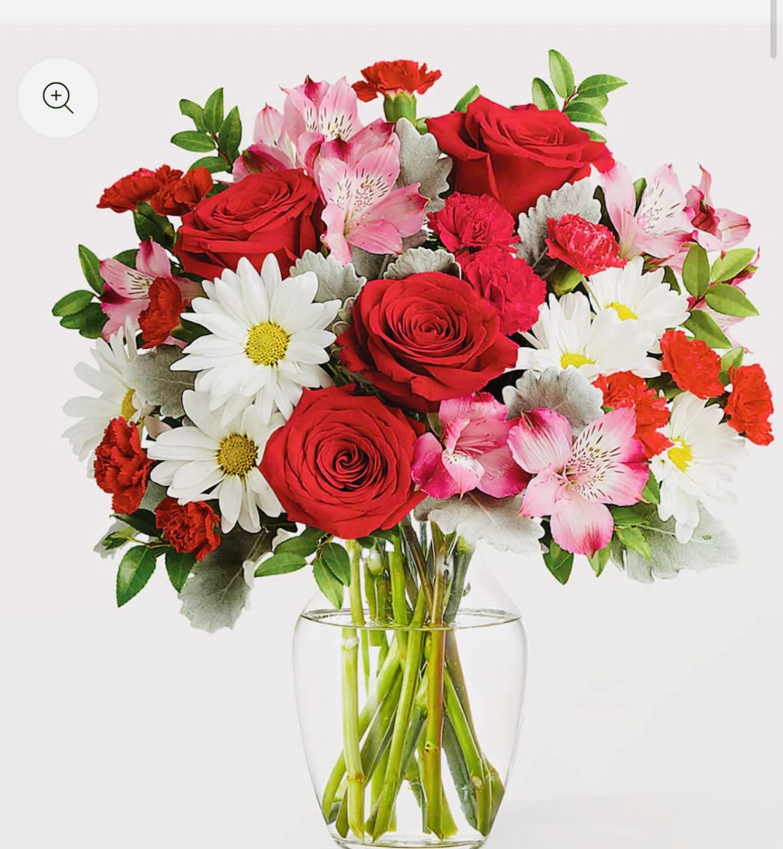 Bouquet of red roses, pink alstroemeria, and white daisies in a clear glass vase