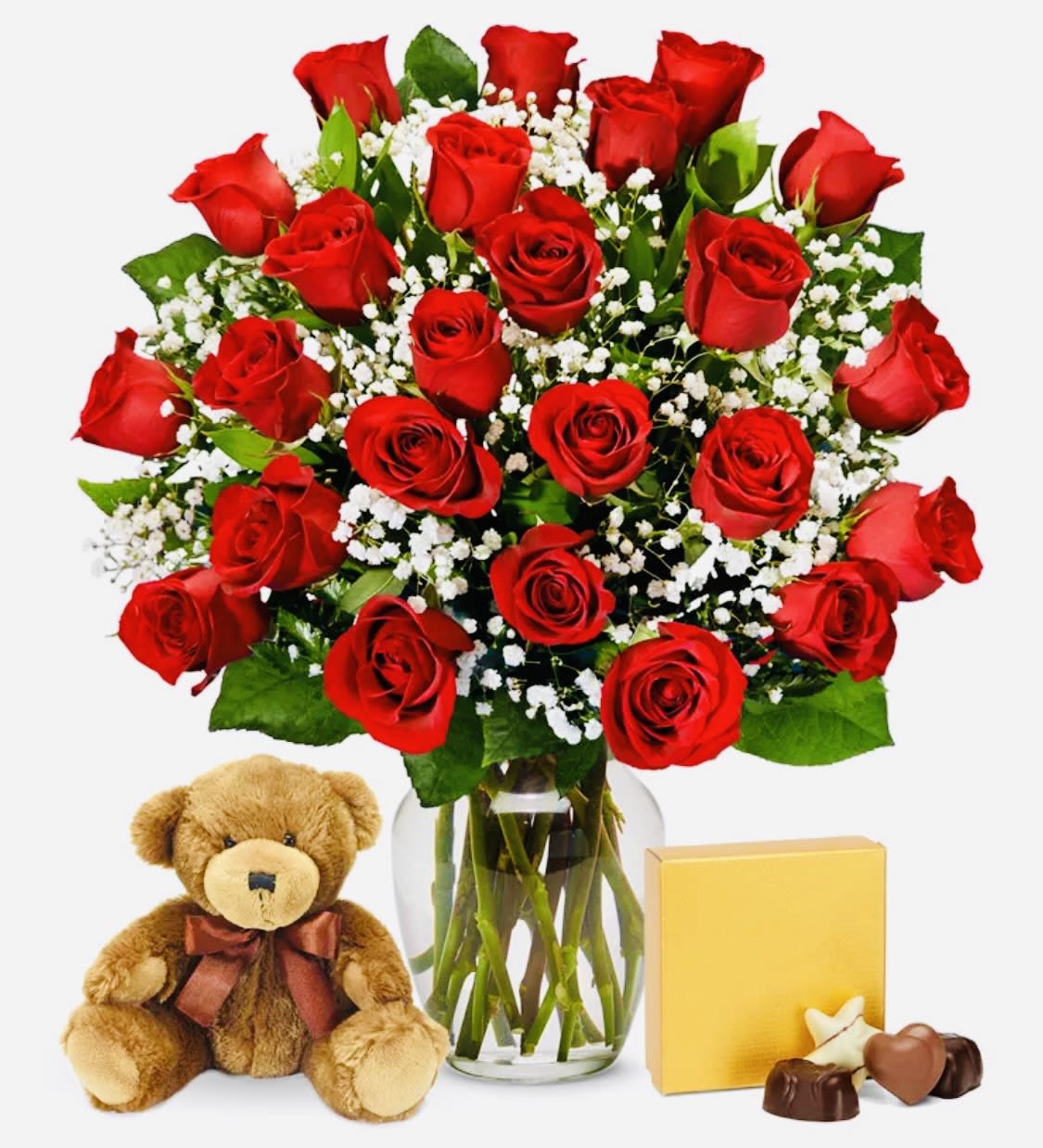 Red roses in a glass vase with a teddy bear and chocolates