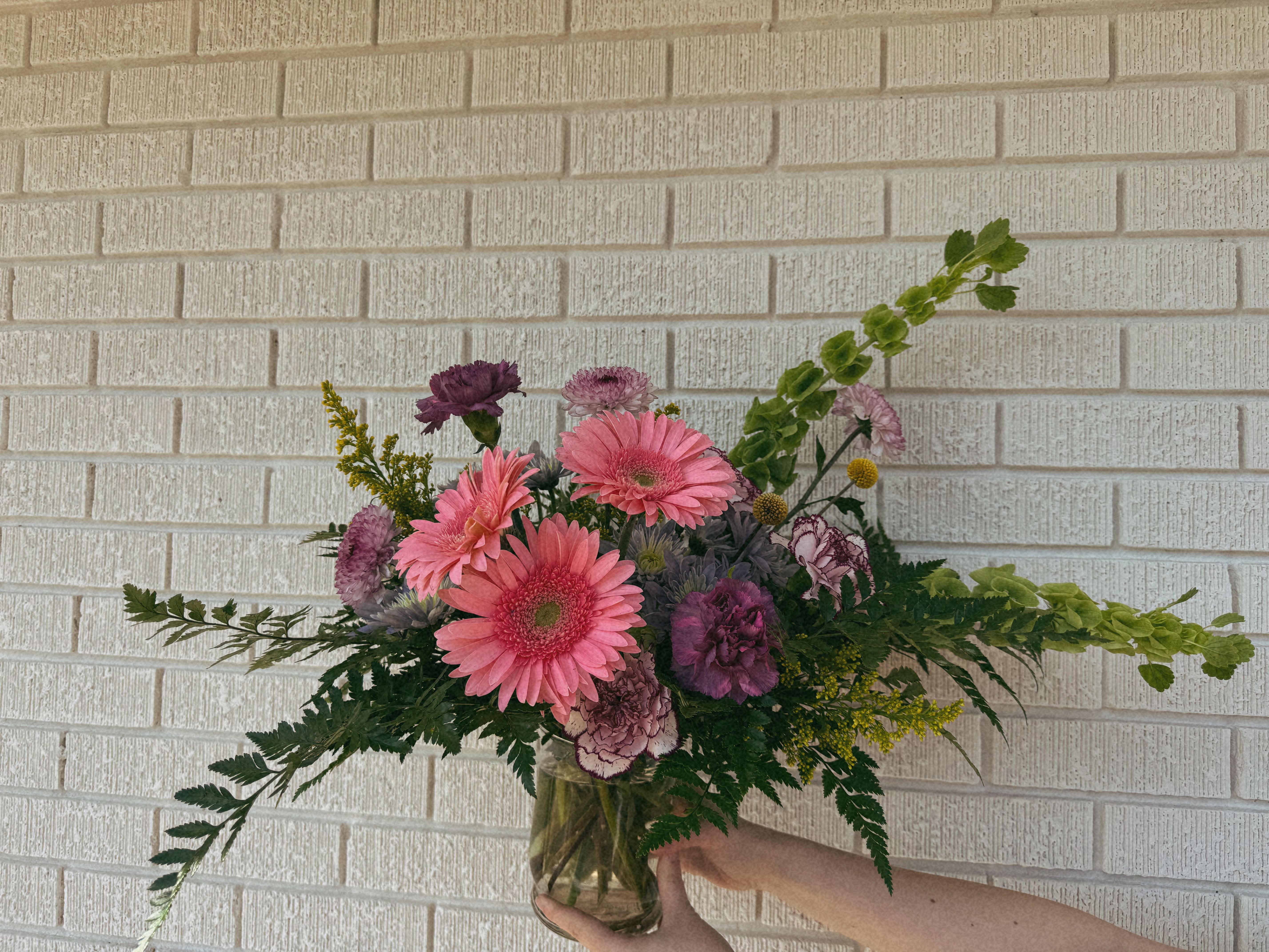 Pink and purple mixed bouquet in a glass vase