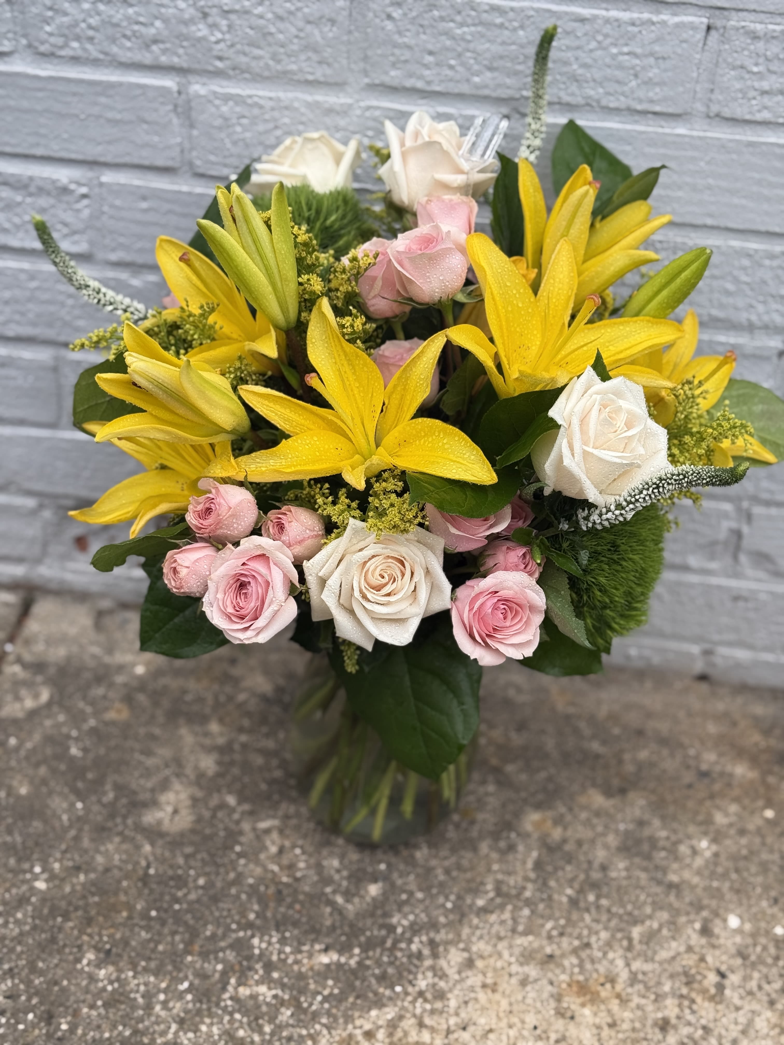 Lovely Flower arrangment - Flower arrangements with Yellow Lilys, pink spray roses, solidego, veronica, roses and green