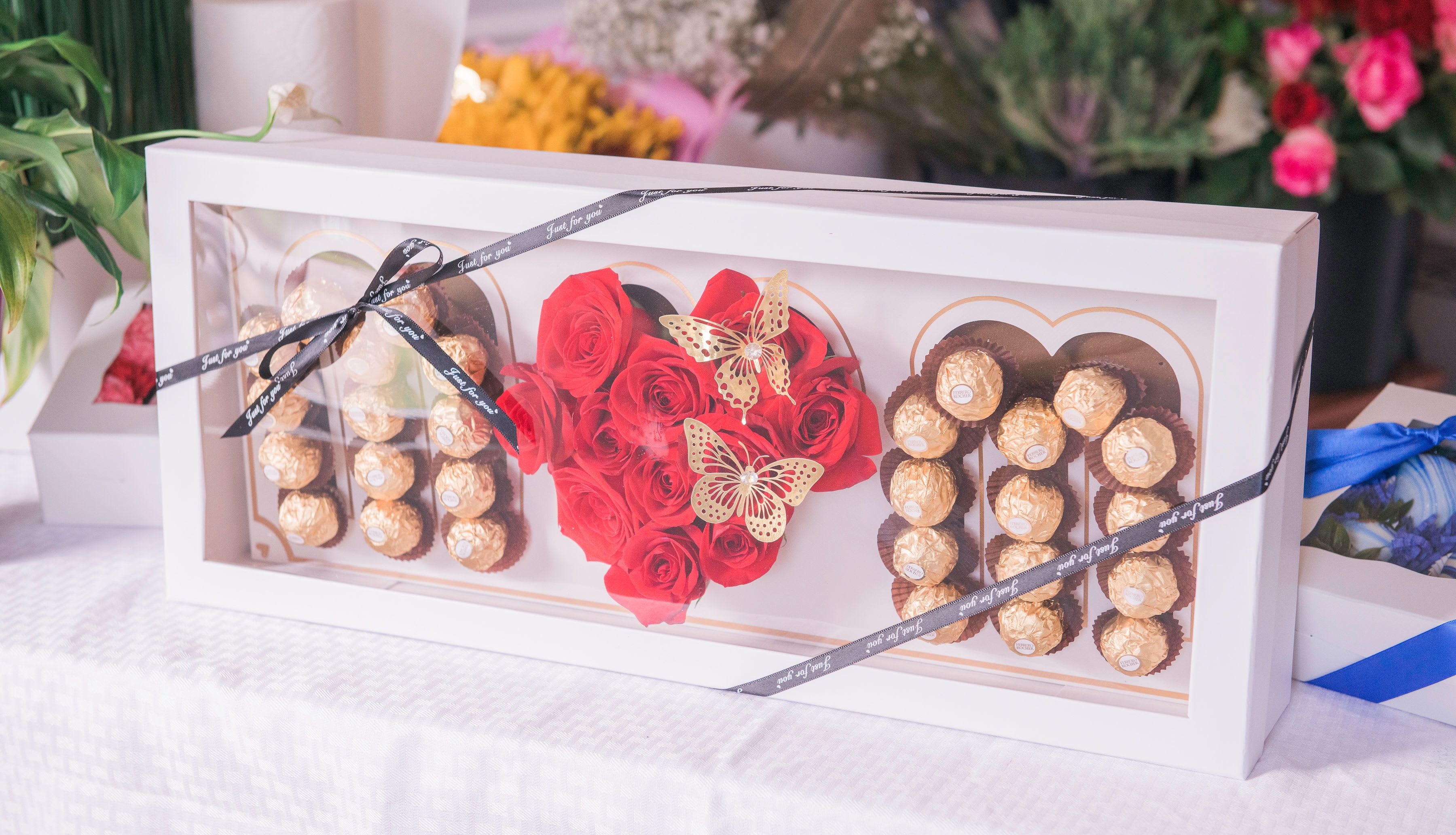 Gift box with red roses and chocolate truffles arranged in heart shapes