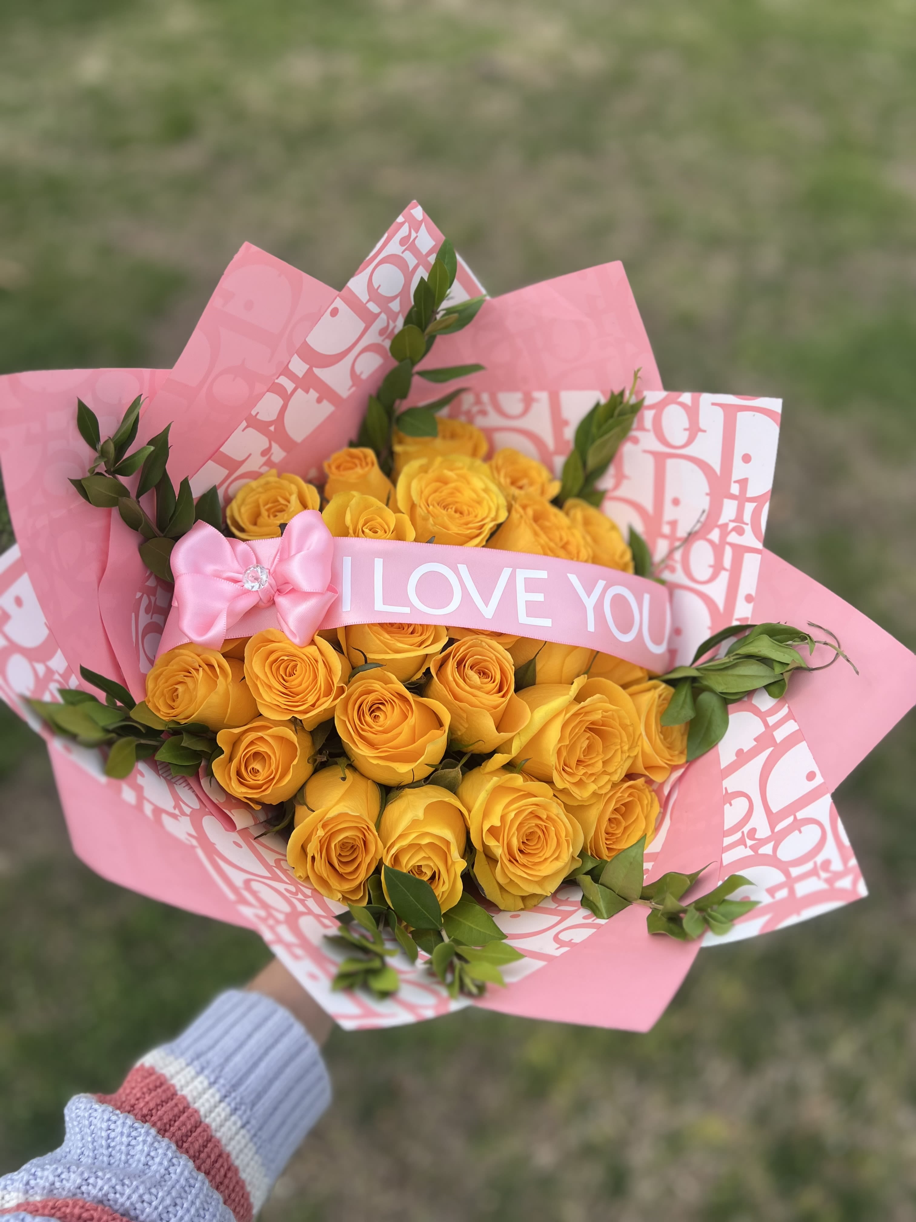 Bouquet of yellow roses wrapped in pink paper with an "I LOVE YOU" ribbon