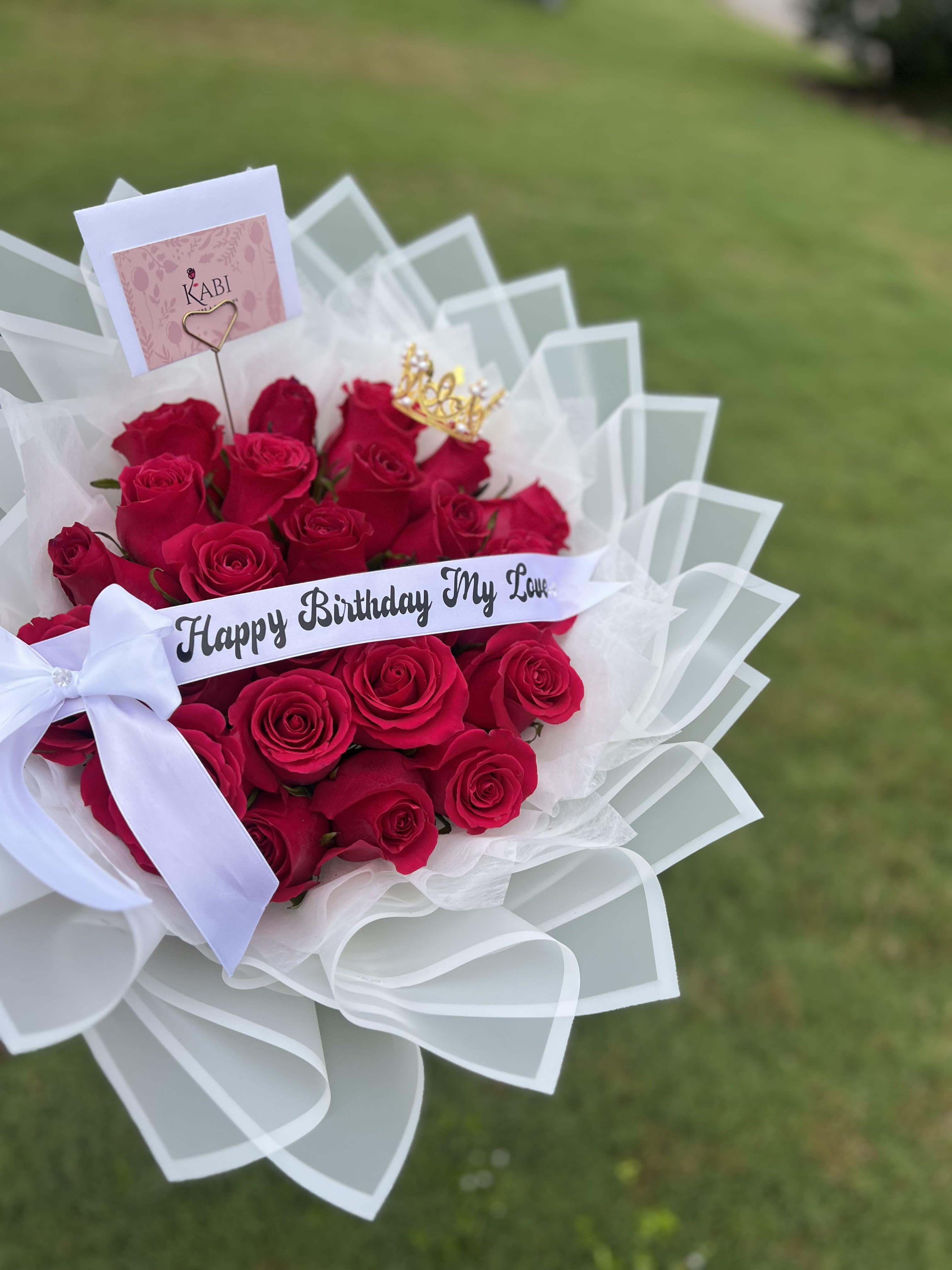 Bouquet of red roses with a birthday ribbon and white wrap