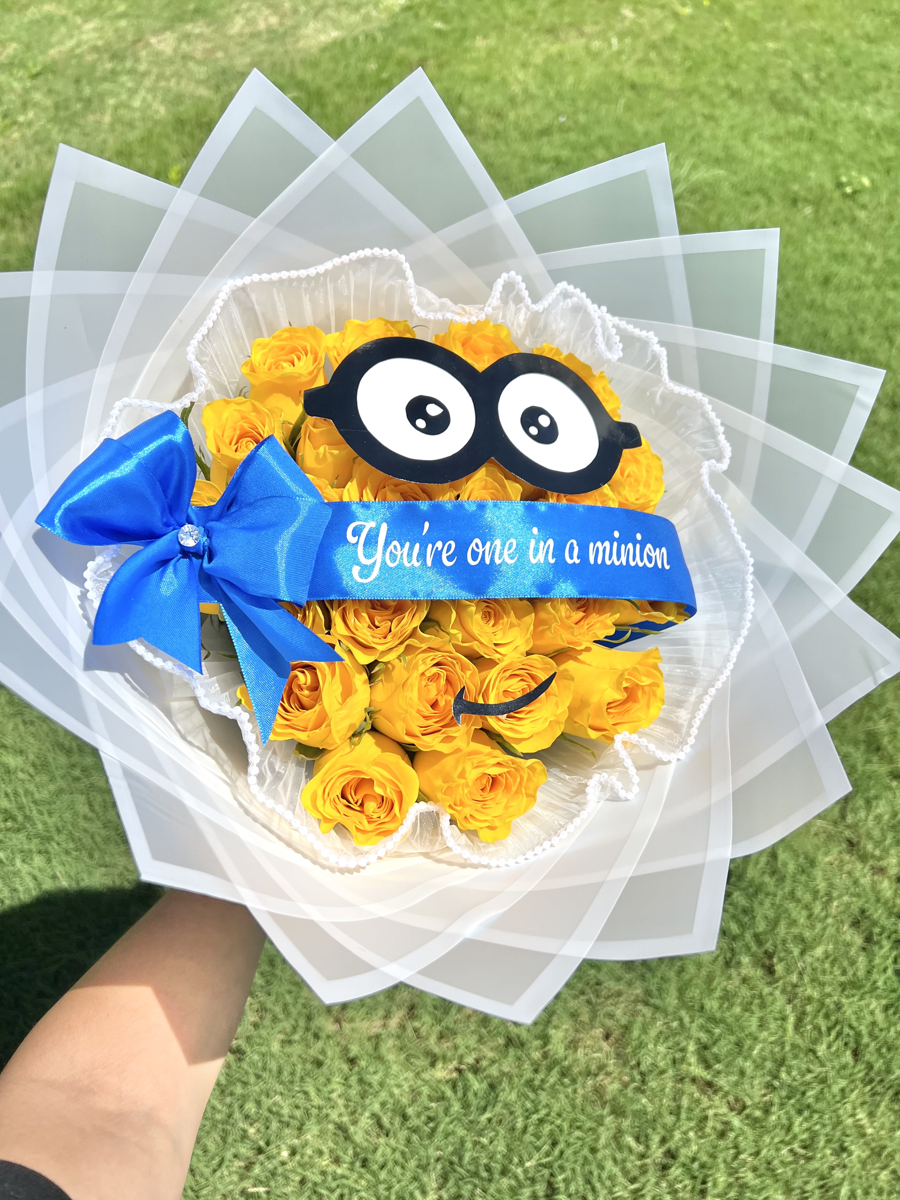 Yellow rose bouquet with a blue ribbon and cartoon glasses decoration