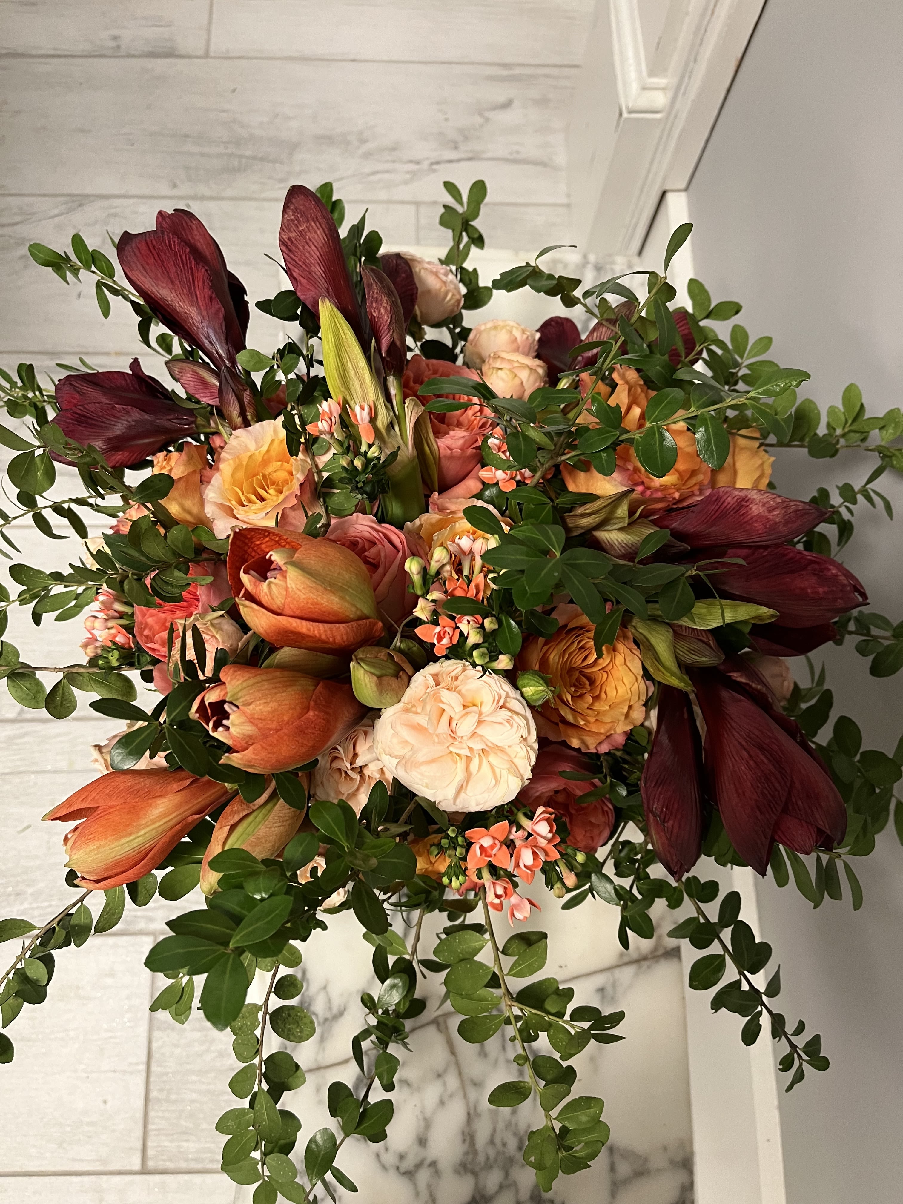 Luxe - Bouvardia, amaryllis, garden roses,  ranunculus, eucalyptus in a vase.