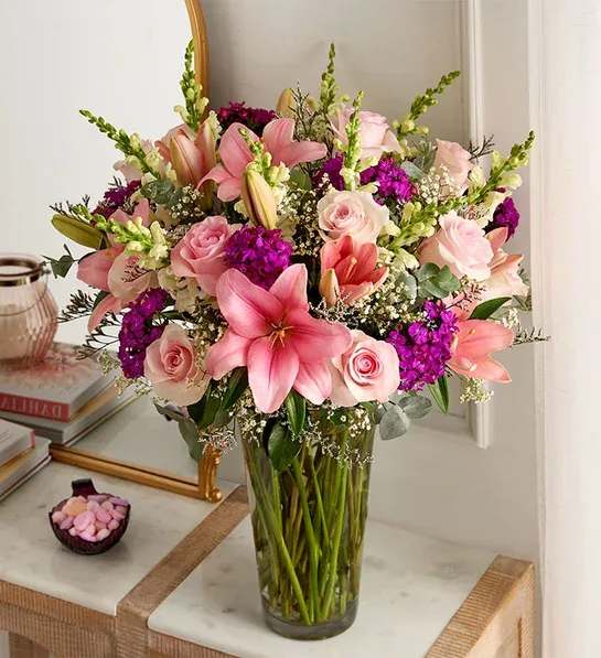 Pink lilies and roses in a clear glass vase