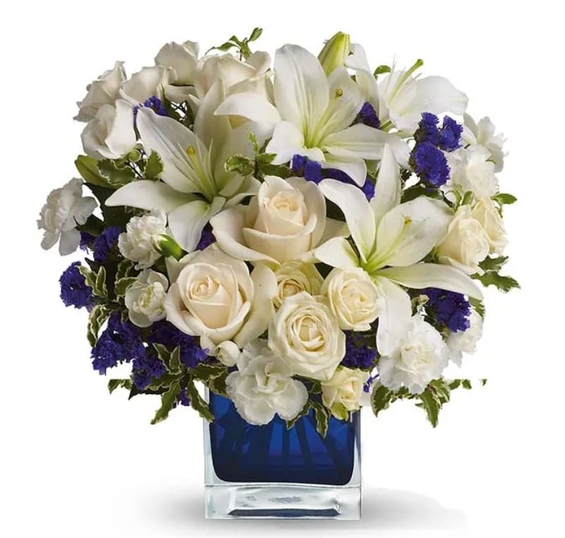 Blue Life - Blue Life arrangement comes in a glass blue cube, includes white lilies, white roses, white alstroemerias, white cushions and daisies, and blue-purple statice. 