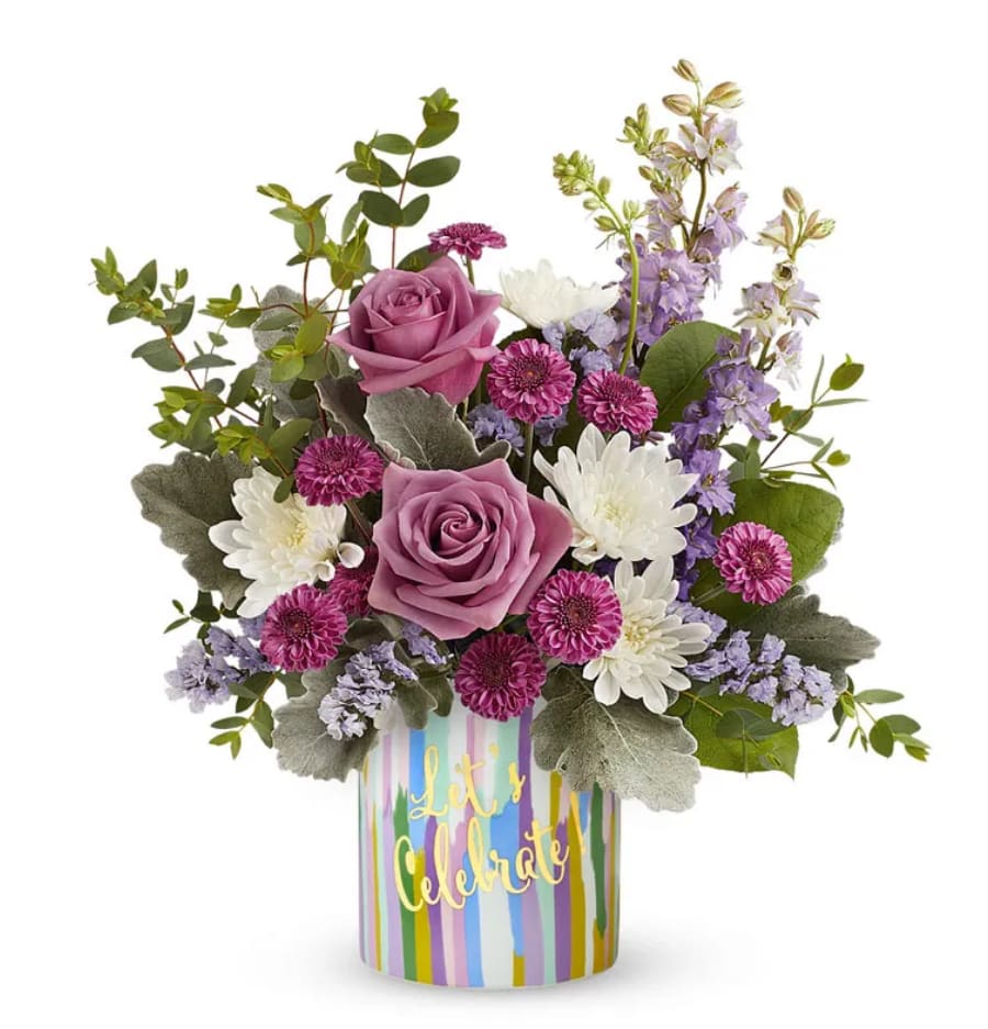Lavender Celebration - This stunning bouquet features elegant lavender roses, paired with vibrant purple button, delicate lavender larkspur, and lavender statice. Accented with lush floral greens, the arrangement is presented in a cheerful keepsake "Let's Celebrate" vase. Perfect for any special occasion, this bouquet adds a touch of joy and elegance, making it an ideal gift to celebrate life's moments with beauty and grace.