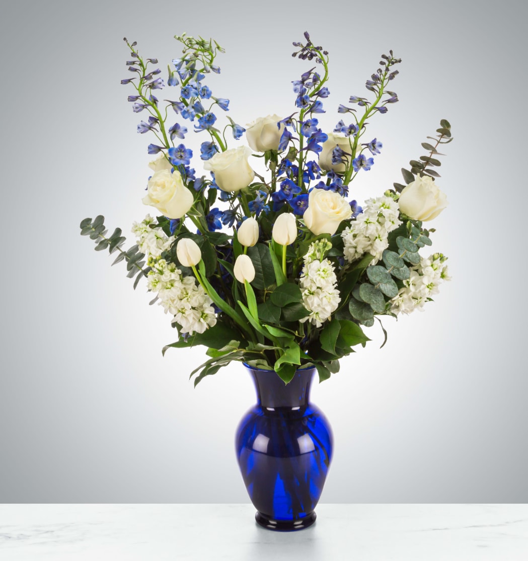 Orion's Belt  - A blue and white arrangement featuring roses, tulips, and delphinium. Send this arrangement to anybody who likes stargazing or the night sky. A perfect gift to send for Hanukkah or the winter season.  Approximate Dimensions: 16"D x 28"H