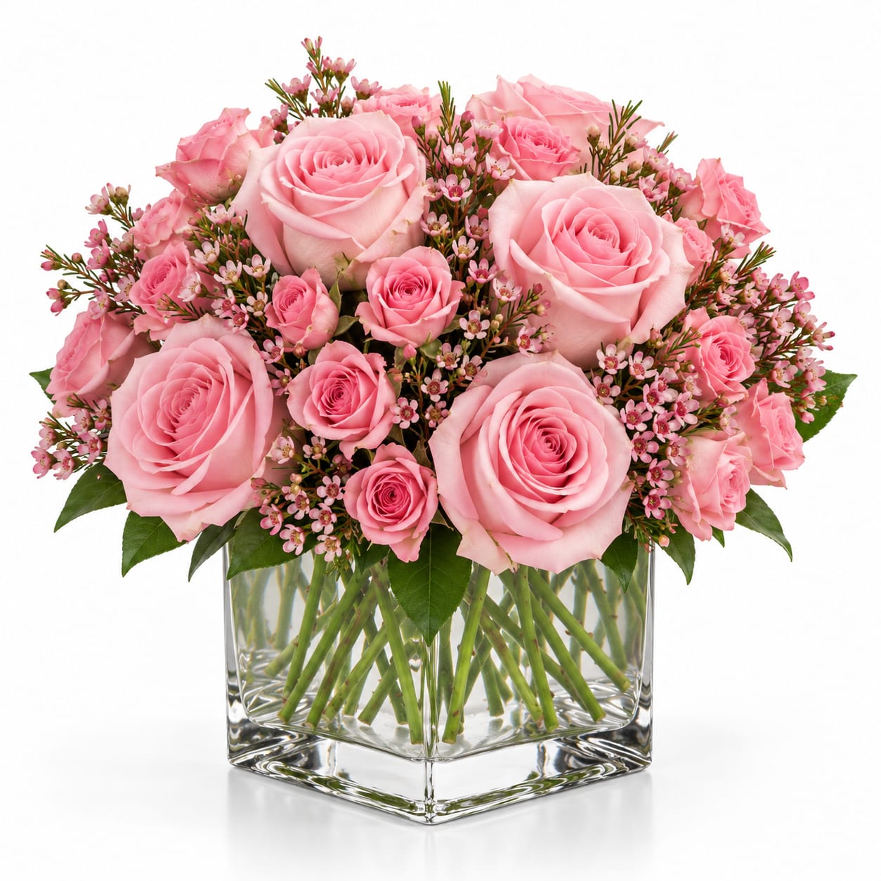 Pink roses arranged in a clear square glass vase