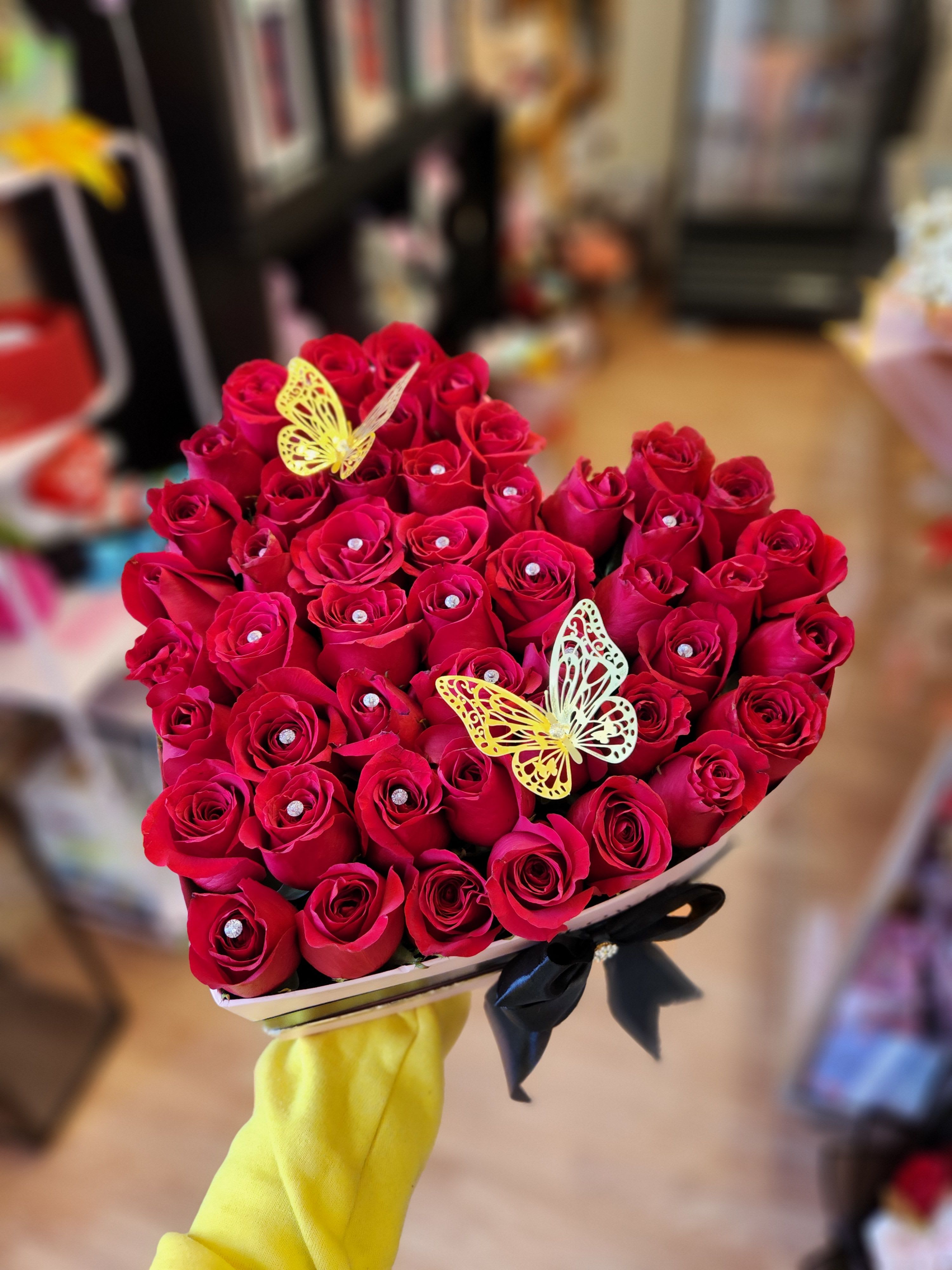 Heart-shaped bouquet of red roses with butterfly decorations