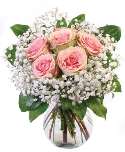 Round glass vase of pink roses surrounded by white filler flowers in a compact bouquet
