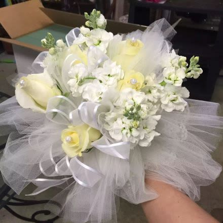Bridal-style hand-tied bouquet of white and pale yellow flowers with tulle and ribbon