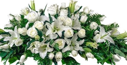 Long white arrangement of roses and lilies in an elongated spray style