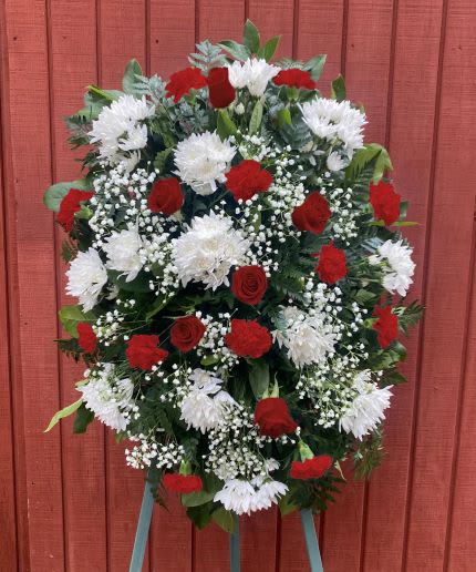 Tall red and white standing spray with roses, carnations, and mums on a metal easel