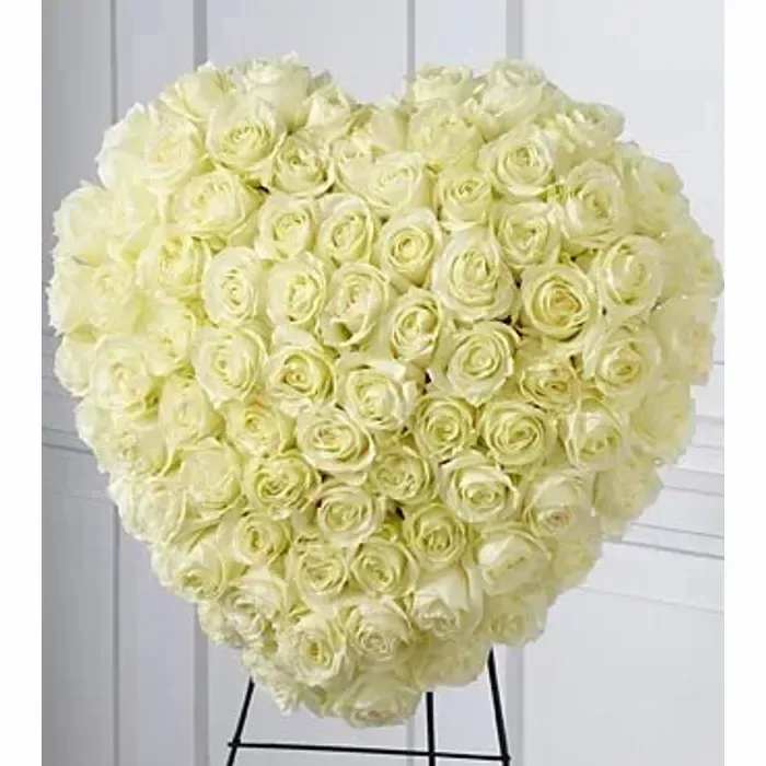 Heart-shaped arrangement of ivory roses on a standing easel
