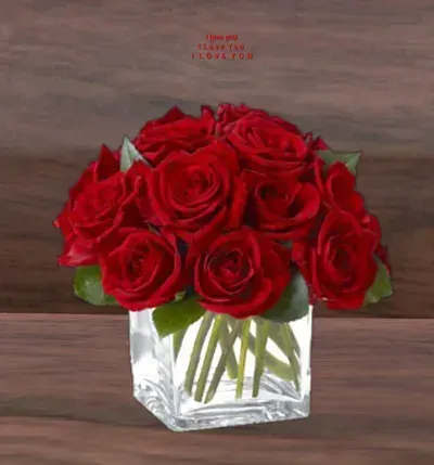 Compact bouquet of red roses in a clear glass cube vase