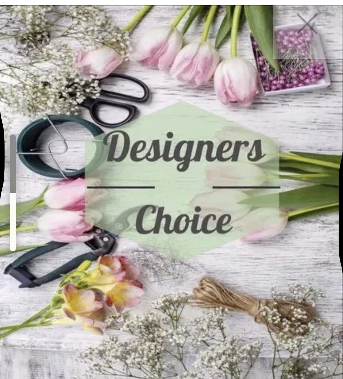 Flat lay of pink tulips, white filler flowers, and floral tools around Designers Choice text.