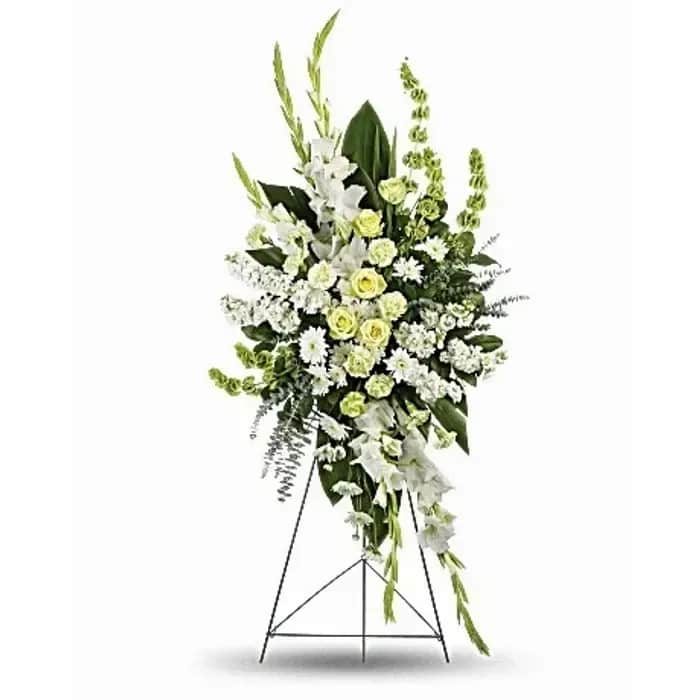Standing floral spray of white and pale green flowers on a metal easel