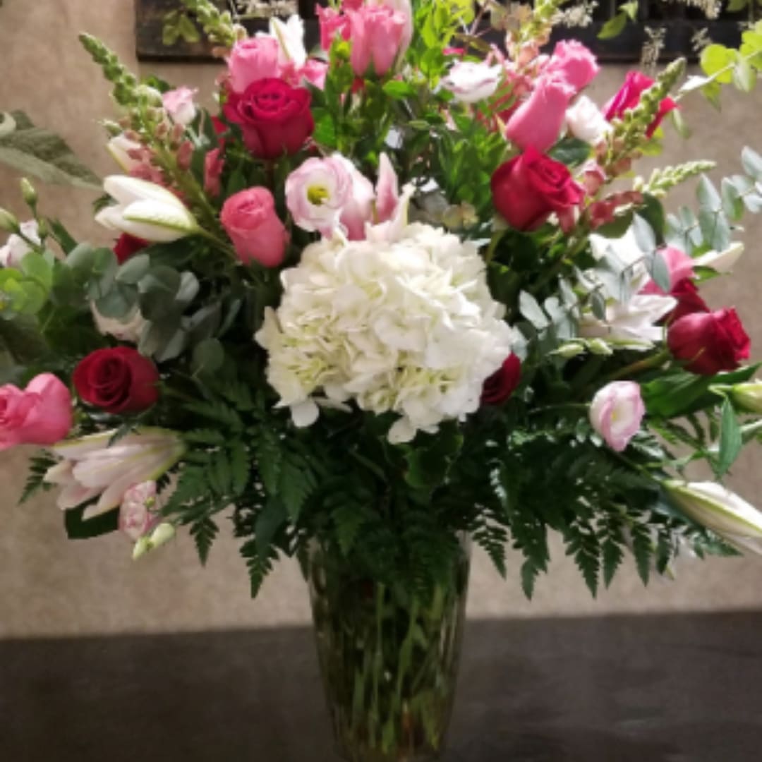 Pink and white mixed flower arrangement in a glass vase
