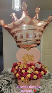 Heart-shaped rose arrangement with a crown balloon above it