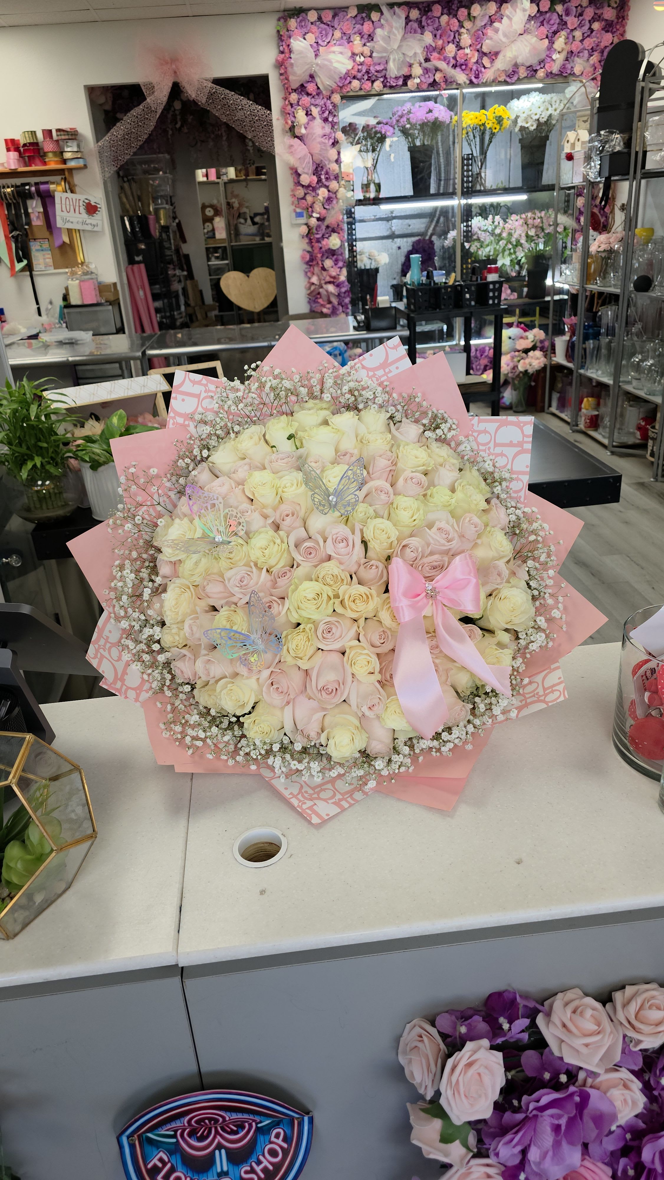 Large bouquet of pale pink and cream roses with a pink ribbon
