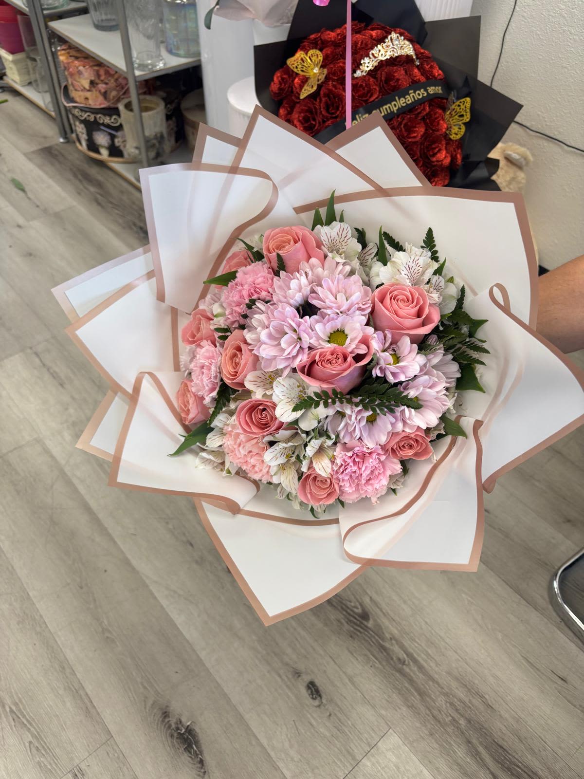 Pink roses and daisies wrapped in white paper with blush trim