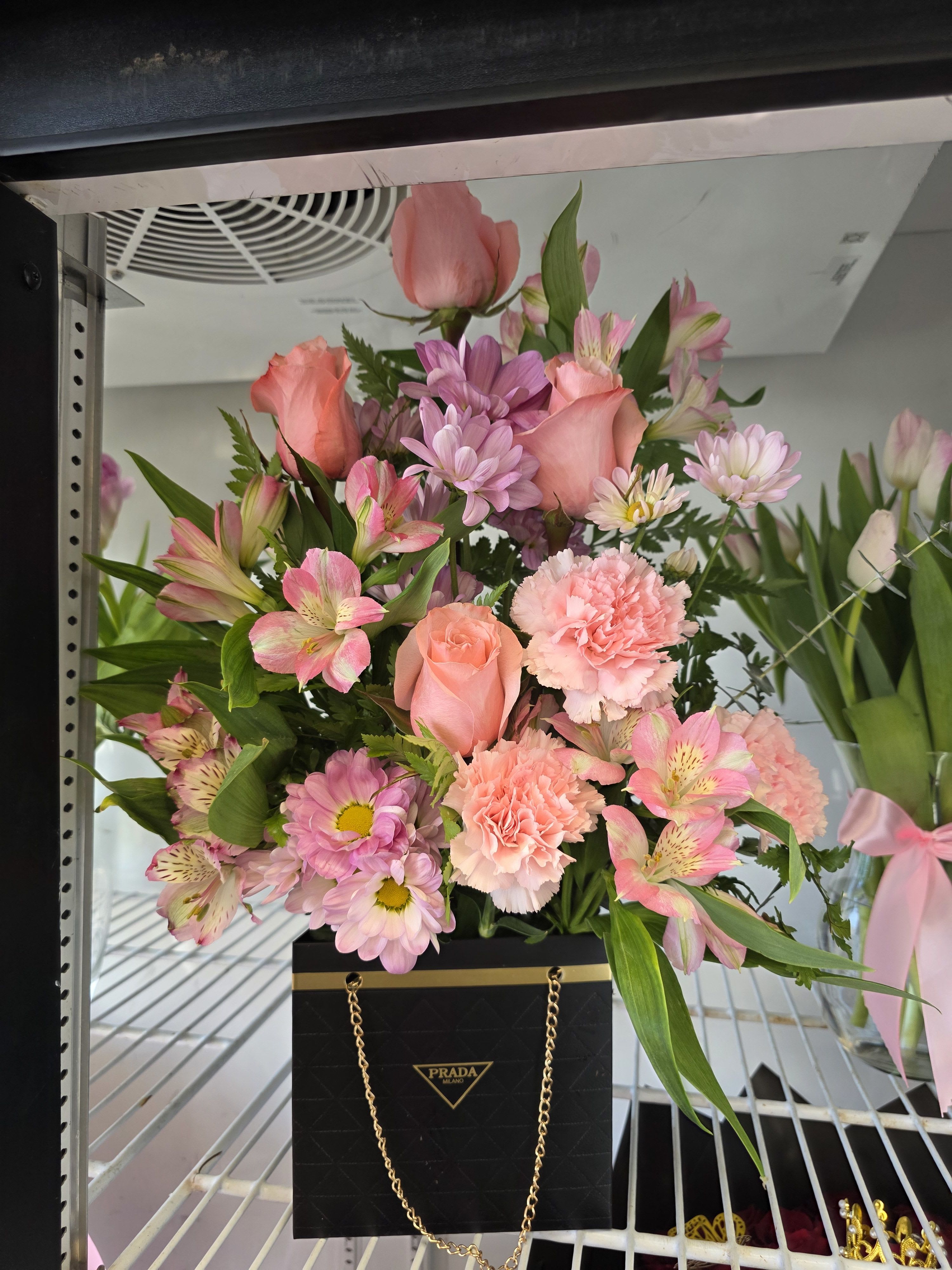 Pink mixed bouquet in a black Prada gift bag