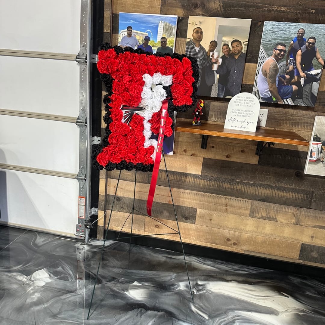 Large floral tribute on an easel in red, black, and white